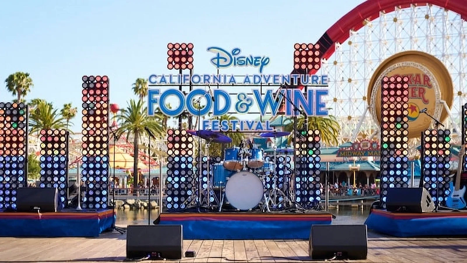 Outdoor stage with drum kit under a Disney California Adventure Food and Wine sign