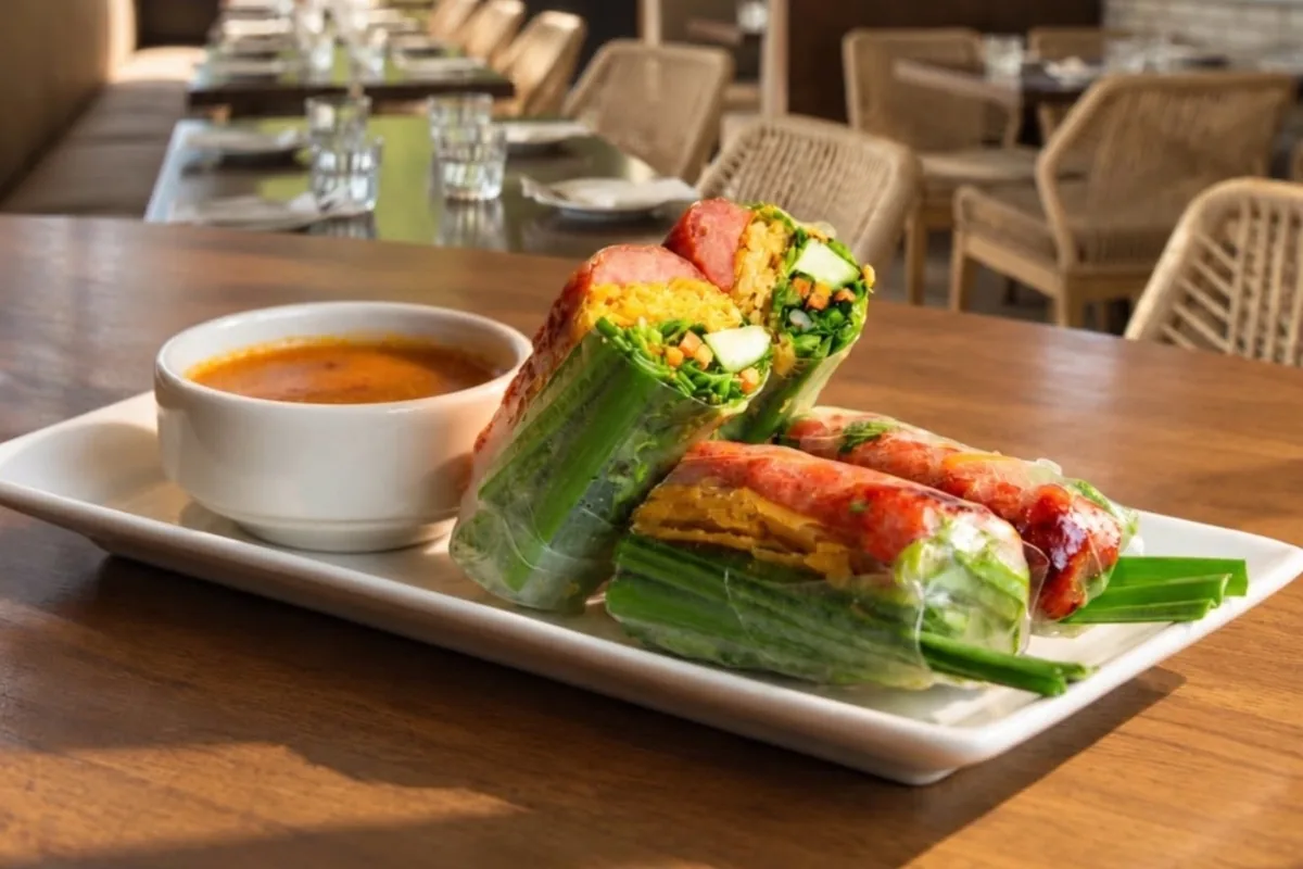 Grilled pork spring rolls with dipping sauce on the patio at Brodard in Long Beach