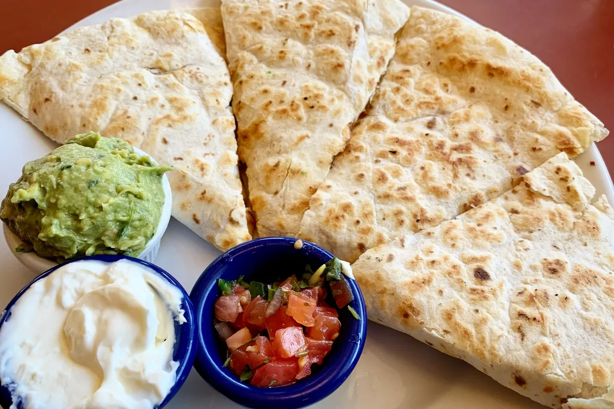 A quesadilla with guacamole, sour cream and salsa at Swingers