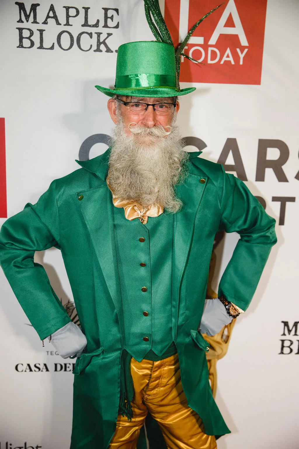 A guest in a bright green coat with a long white beard