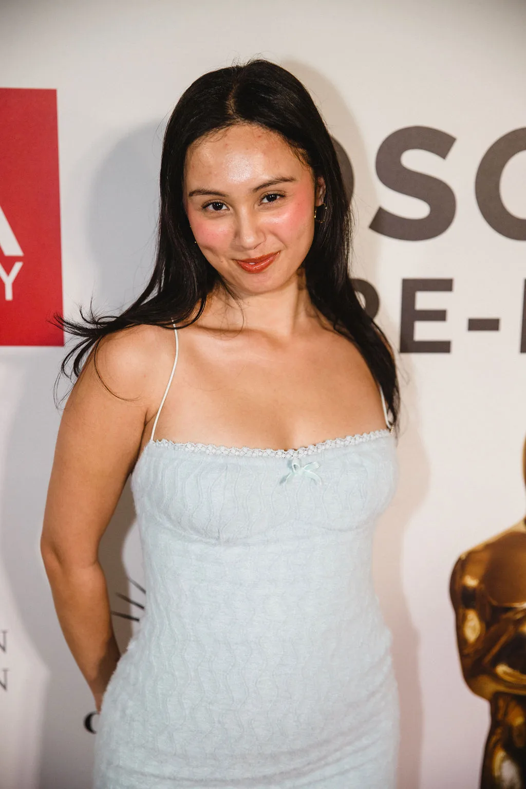 Portrait of a guest in a pale blue camisole at the backdrop