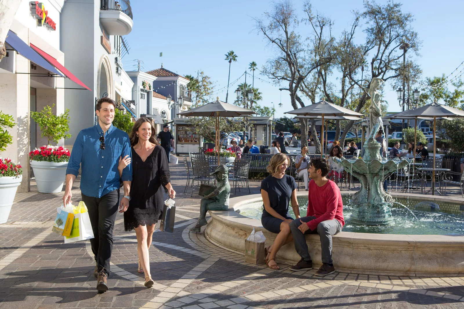 Shoppers and a fountain plaza in Claremont Village Square.
