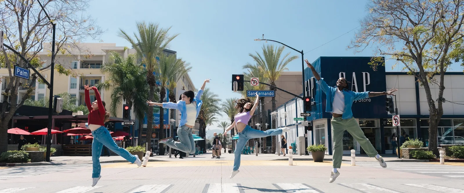 Dancers leaping on a sunlit downtown shopping street