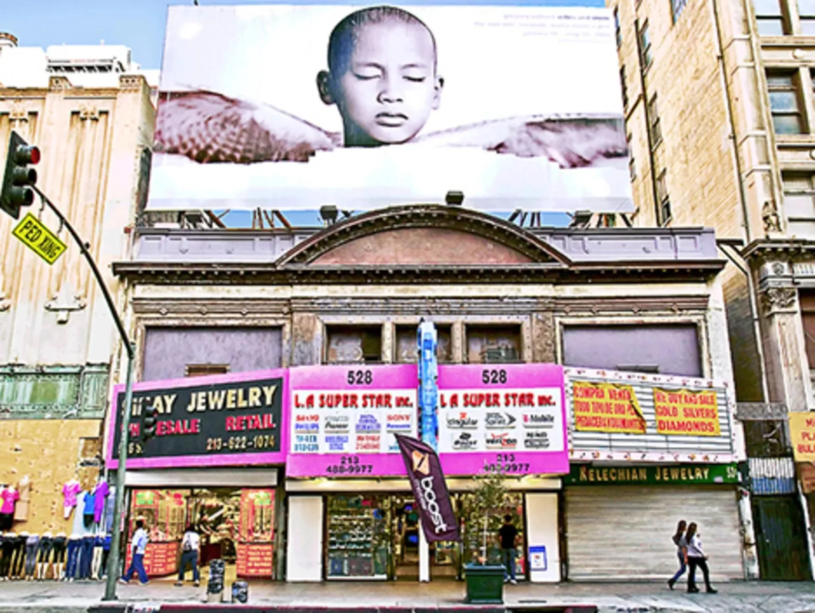 Historic facade covered with jewelry store signs beneath a large billboard