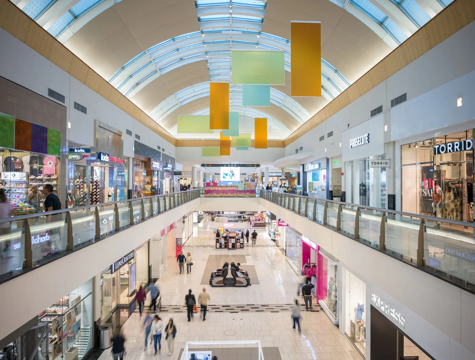 Enclosed mall interior with barrel vault skylight and colorful hanging panels