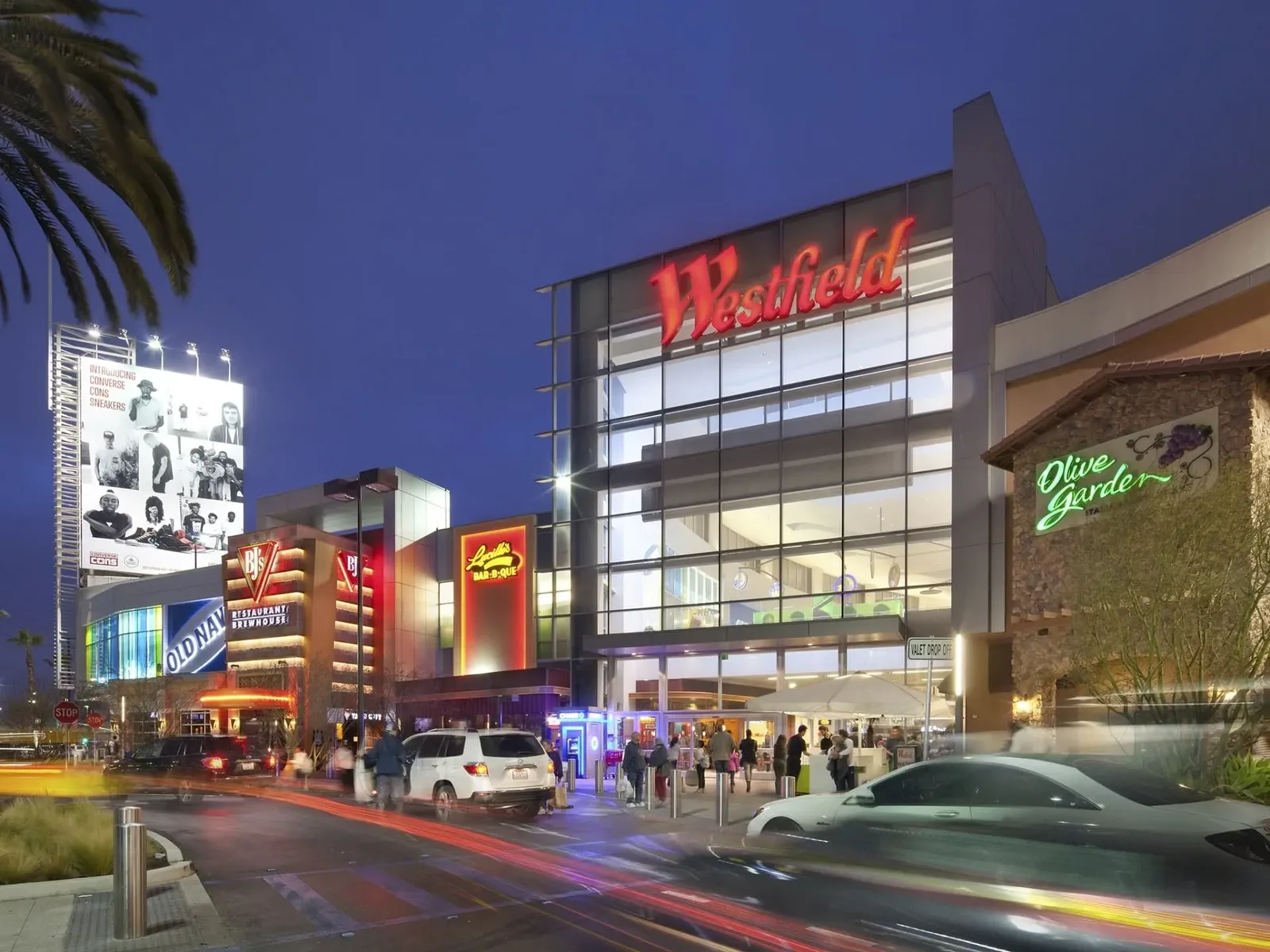 Lit mall entrance and signage at dusk
