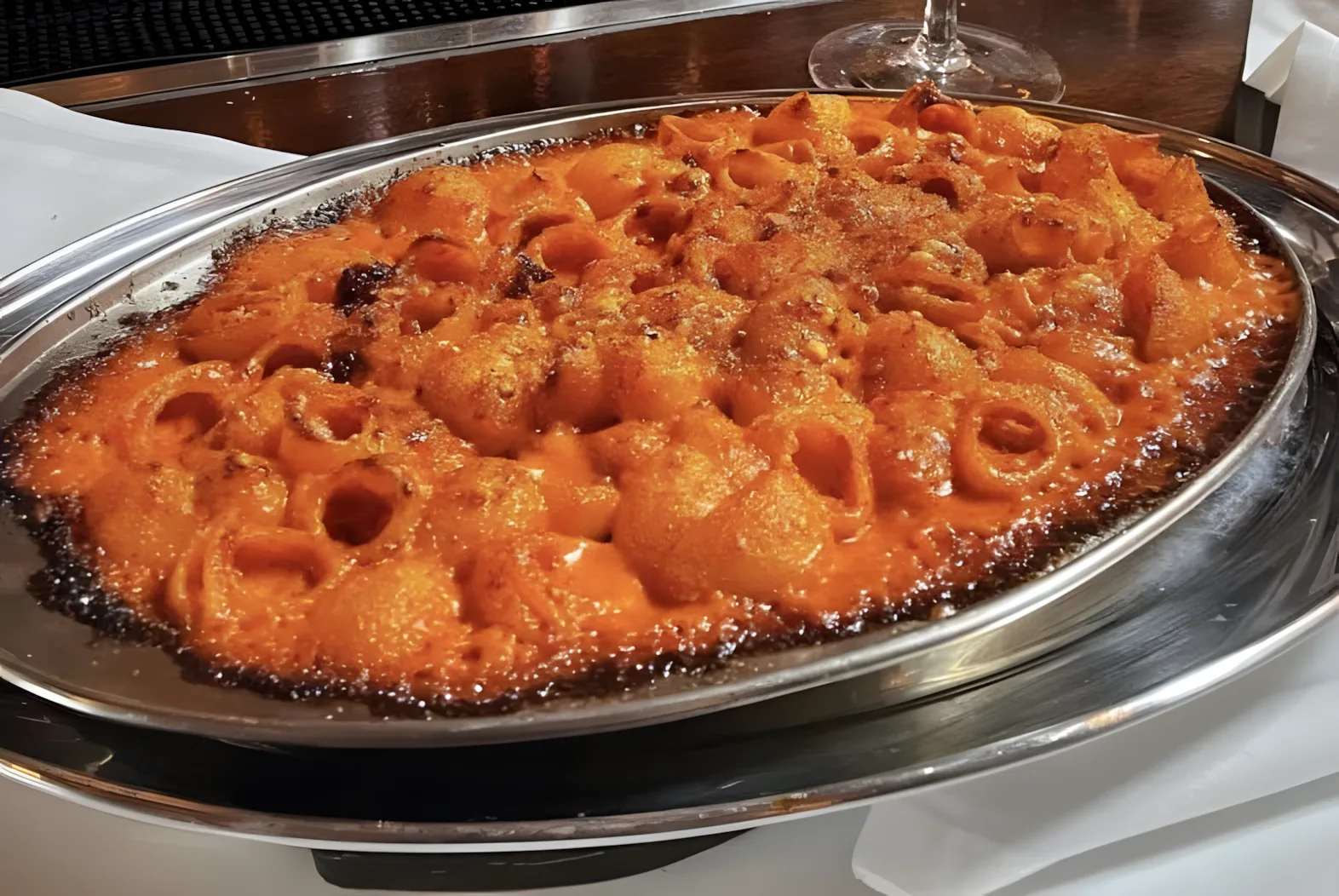 Silver pan of baked pasta rings in tomato sauce