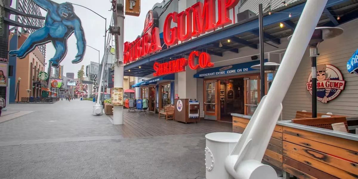 Boardwalk storefront row with restaurant signage and a gorilla mural