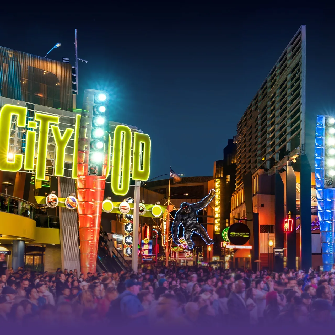 Neon-lit outdoor shopping promenade at night with tall signage