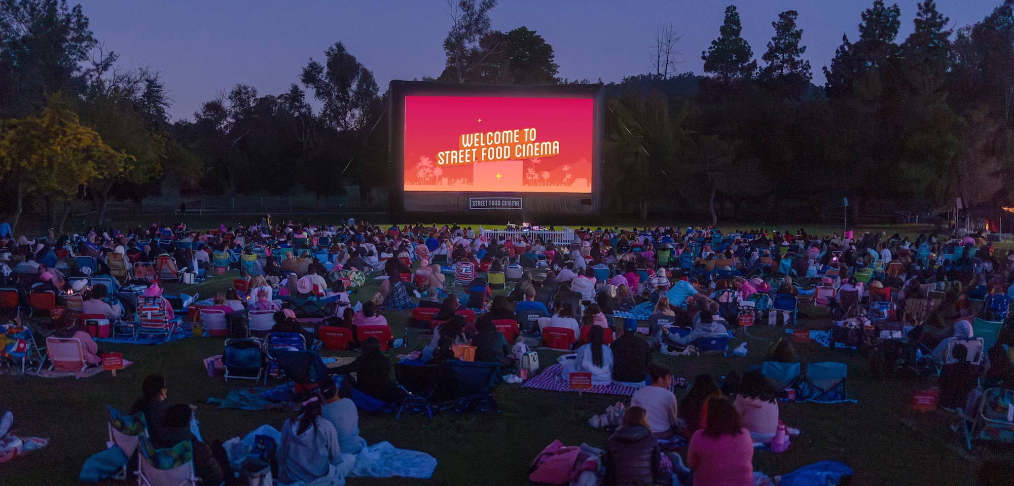 Moviegoers gather for Street Food Cinema's Yuletide Cinemaland outdoor holiday screenings at Heritage Square Museum in Los Angeles.