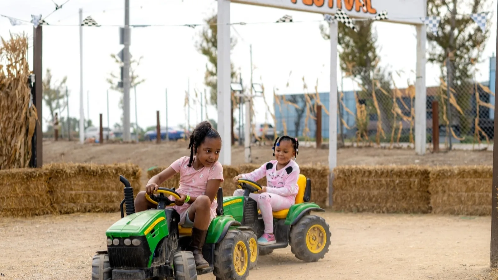 Children riding mini tractors at Pa's Pumpkin Patch.