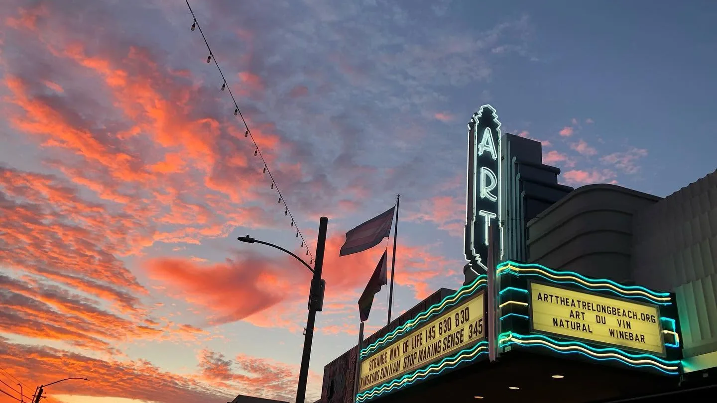 The neon blade sign of the Art Theatre on Retro Row in Long Beach against a pink sunset sky