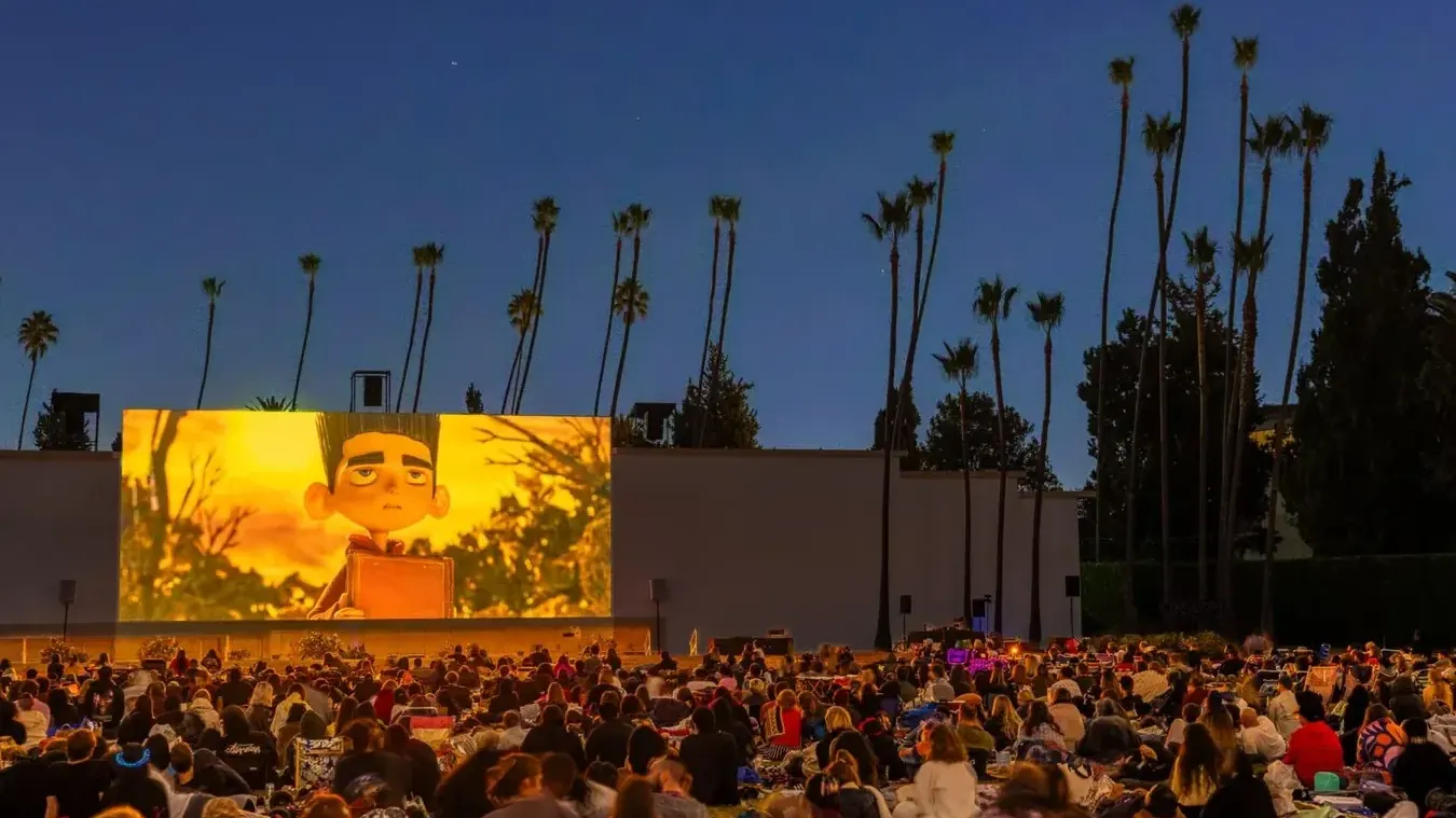 A Cinespia crowd under the palms at Hollywood Forever Cemetery at dusk